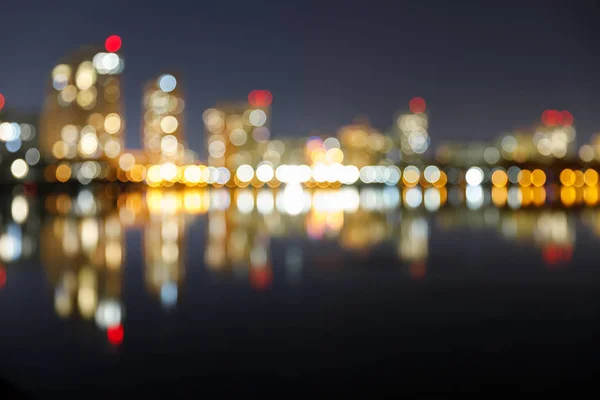 Aydınlatılmış Binalar Yansıma Bokeh Işıkları Ile Karanlık Şehir Siluetinin Bulanıklaştığı — Stok fotoğraf