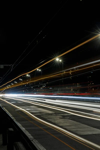 在晚上繁忙的城市路上长时间暴露明亮的灯光 — 图库照片