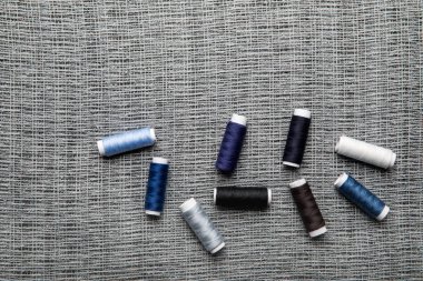 kopya alanı ile bir bez üzerinde dağınık mavi ve gri iplik bobinleri üst görünümü