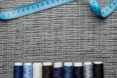top view of blue and grey thread coils on sackcloth with measuring tape and copy space clipart
