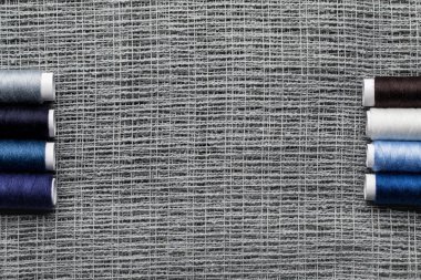 top view of blue and grey cotton thread coils on sackcloth with copy space clipart