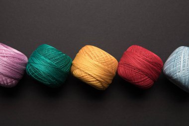 top view of arranged colorful balls of knitting yarn isolated on black clipart