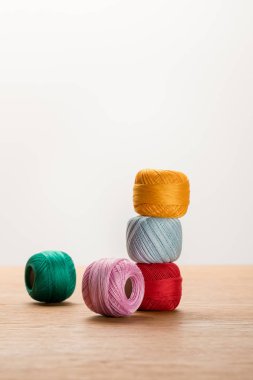 colorful knitting yarn balls on wooden table isolated on white with copy space clipart