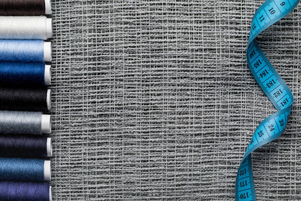 верхний вид катушек синей и серой резьбы на мешковине с измерительной лентой и копировальным пространством
