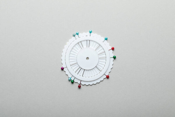 top view of sewing pins in round container isolated on grey