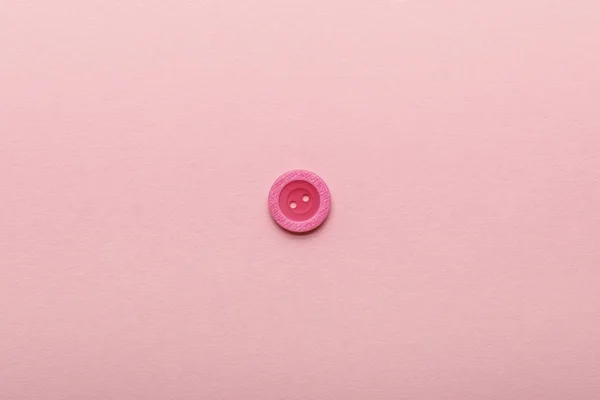 コピースペースでピンクに分離された衣類ボタンのトップビュー — ストック写真