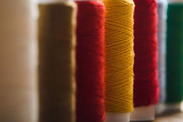 close up view of colorful cotton thread coils in row