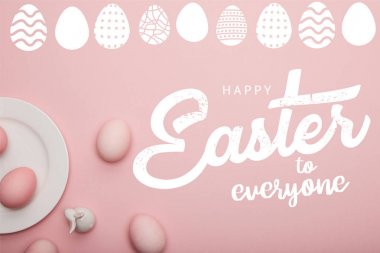 Herkes yazı için beyaz Mutlu Paskalya ile pembe yüzeyde plaka ve dekoratif tavşan yakın boyalı pembe yumurta üst görünümü