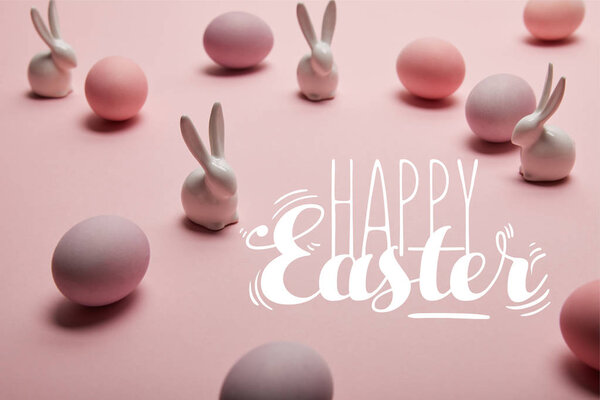 pink painted chicken eggs with decorative rabbits and happy Easter lettering 