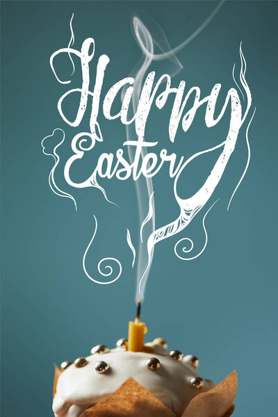 selective focus of traditional Easter cake with fireless candle and smoke on blue background with happy easter lettering