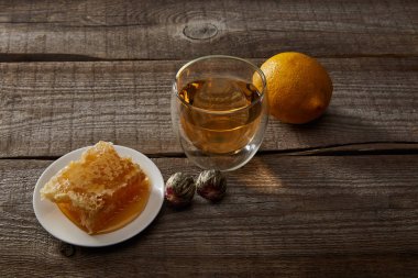 ahşap yüzeyüzerinde geleneksel çin çiçeklenme çay, limon ve petek cam