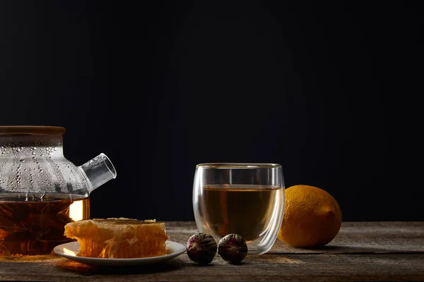 黒で隔離された木製のテーブルに咲く紅茶 ガラス レモン ハニカムを備えた透明なティーポット — ストック写真