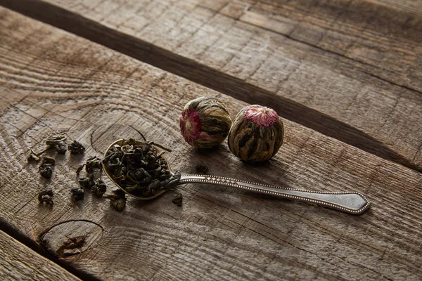Κουτάλι Πράσινο Τσάι Και Ανθισμένες Μπάλες Τσαγιού Ξύλινο Τραπέζι — Φωτογραφία Αρχείου