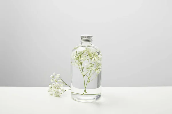 透明瓶中的有机美容产品 灰色背景的白色野花 — 图库照片