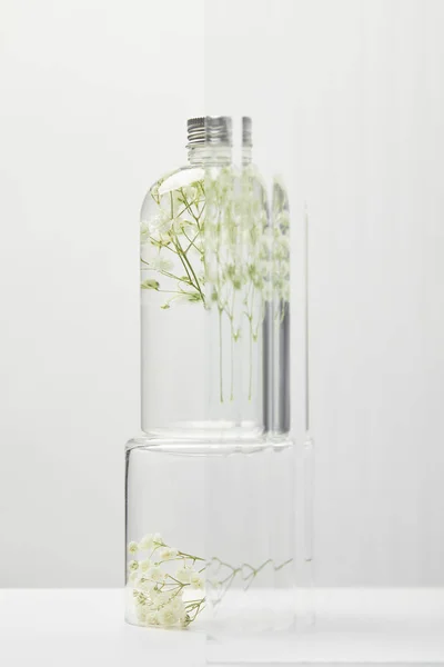 Produto Cosmético Orgânico Garrafa Transparente Com Flores Silvestres Atrás Vidro — Fotografia de Stock