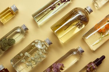 sarı arka plan üzerinde organik güzellik ürünleri ve kurutulmuş kır çiçekleri ile şişe üst görünümü 