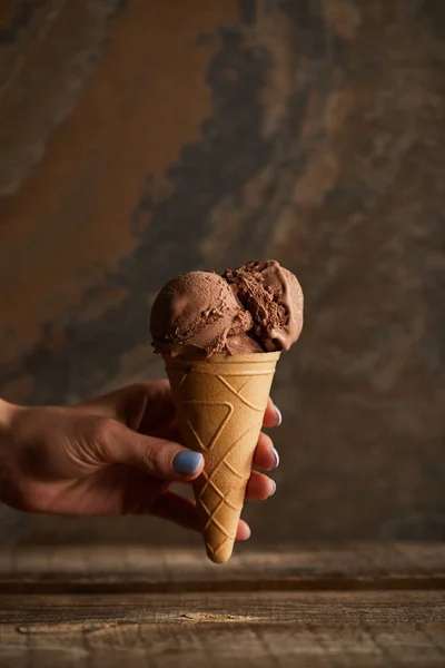 Cropped View Woman Holding Chocolate Ice Cream Cone Wooden Table — Stock Photo, Image