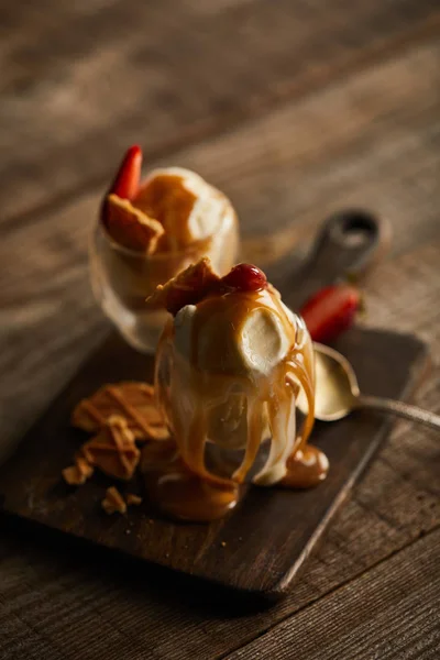 Leckeres Eis Mit Erdbeeren Und Karamell Gläsern Auf Schneidebrett — Stockfoto