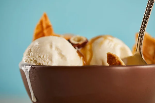 近距离观看碗与美味的冰淇淋片华夫饼和勺子在蓝色 — 图库照片