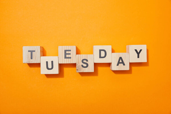 top view of wooden blocks with letters on orange surface
