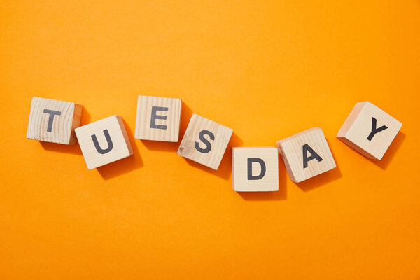 top view of wooden blocks with letters on orange surface