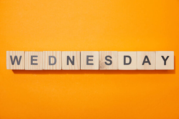 top view of wooden blocks with letters on orange surface