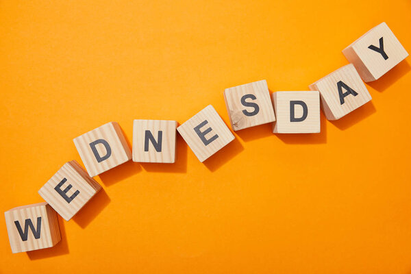 top view of wooden blocks with letters on orange surface