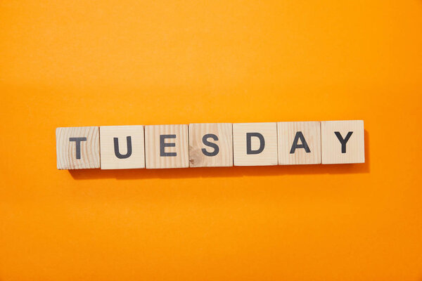 top view of wooden blocks with letters on orange surface