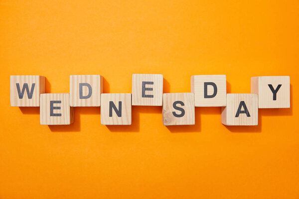 top view of wooden blocks with letters on orange surface