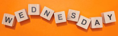 panoramic shot of wooden cubes with letters on orange surface clipart