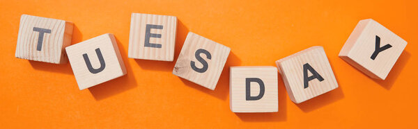 panoramic shot of wooden cubes with letters on orange surface
