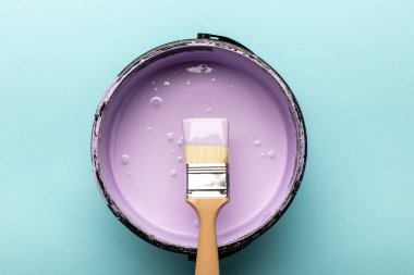 top view of bucket with purple paint and brush on blue clipart