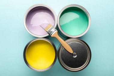 top view of tins of paints and brush on blue surface clipart