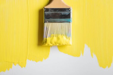 top view of brush on painted yellow surface clipart