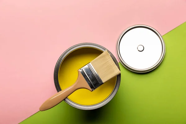在粉红色和绿色表面上用黄色油漆和刷子的锡的顶视图 — 图库照片
