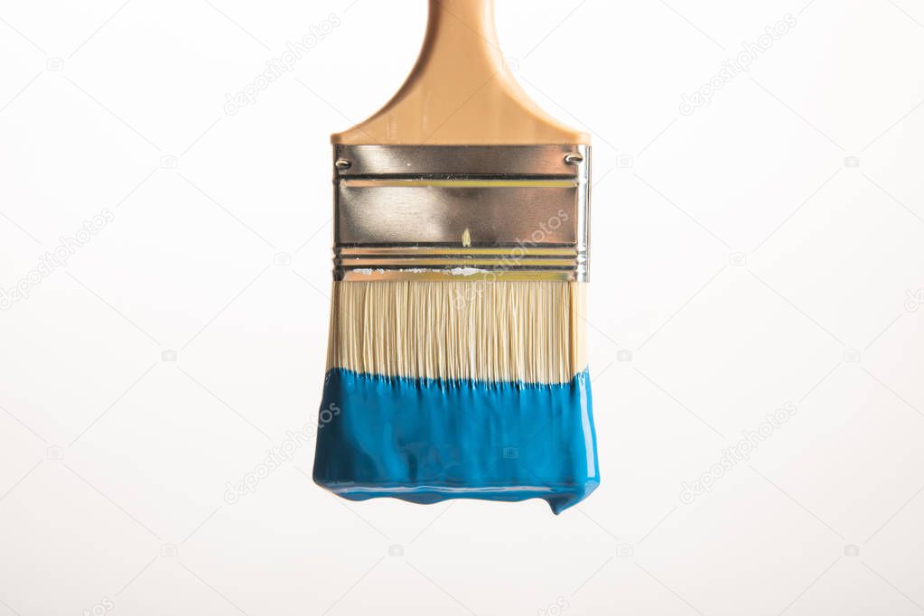 wooden brush with blue paint isolated on white