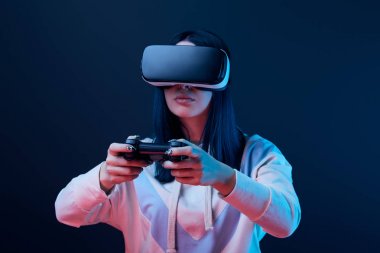 Kiev, Ukrayna - 5 Nisan 2019: Mavi sanal gerçeklik kulaklık giyerken video oyunu oynayan genç kadının seçici odak noktası 