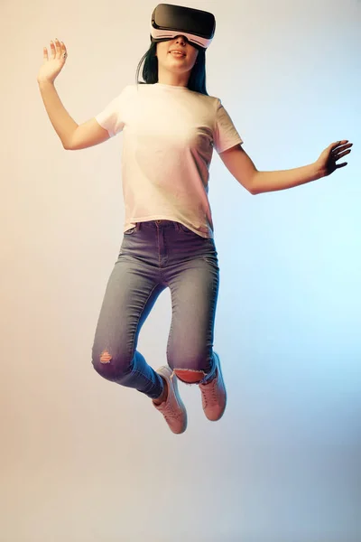 Cheerful Young Woman Virtual Reality Headset Jumping Gesturing Beige Blue — Stock Photo, Image