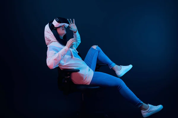 Chica Sorprendida Gestos Uso Auriculares Realidad Virtual Mientras Sienta Silla — Foto de Stock