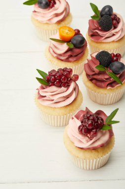beyaz yüzeyüzerinde krema ve çilek ile cupcakes seçici odak