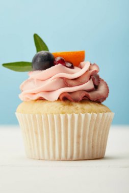 beyaz yüzeyde krem ile lezzetli cupcake mavi izole