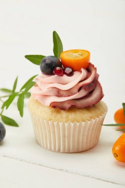 beyaz yüzeyüzerinde krema ve kumquats ile cupcake