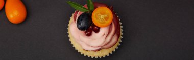 siyah yüzeyde krem ve meyve ile cupcake panoramik çekim