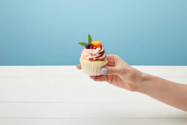 Bijgesneden Weergave Van Vrouw Houden Zoete Cupcake Geïsoleerd Blauw — Stockfoto