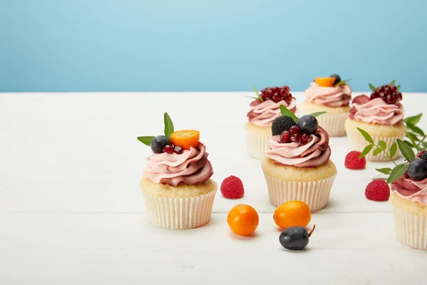 Édes Cupcakes Tejszínes Gránát Fehér Felületen Izolált Kék — Stock Fotó