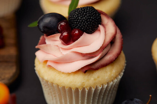 sweet cupcake with cream, garnet, blackberry and grape 