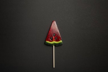 siyah arka plan üzerinde ahşap sopa üzerinde karpuz lezzetli lolipop üst görünümü