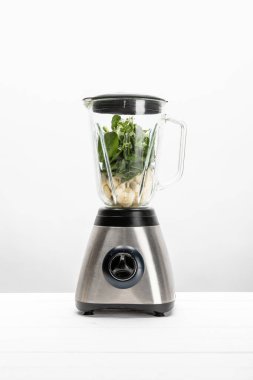 beyaz blender kesilmiş muz ile yeşil taze ıspanak yaprakları 