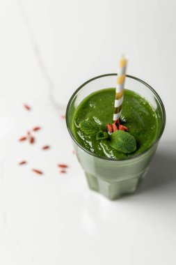 beyaz saman ile cam goji çilek ve nane ile yeşil smoothie seçici odak 