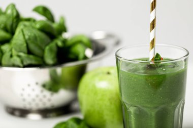 ispanak yaprakları ve beyaz elma yakın saman ile cam lezzetli yeşil smoothie seçici odak 